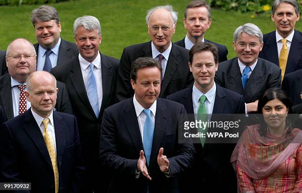 Britain's Prime Minister David Cameron calls an end to a group picture with his new cabinet ministers in the garden of Number 10 Downing Street on...