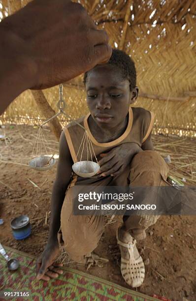 Gold buyer, weighs gold of a young gold panner on May 9 on a gold panning site near Ouahigouya. Burkina Faso more than doubled its gold production in...