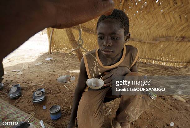 Gold buyer, weights the gold of a young gold panner on May 9 on a gold panning site near Ouahigouya. Burkina Faso more than doubled its gold...