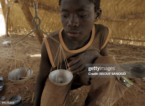 Gold buyer, weights gold pieces of a young gold panner on May 9 on a gold panning site near Ouahigouya. Burkina Faso more than doubled its gold...