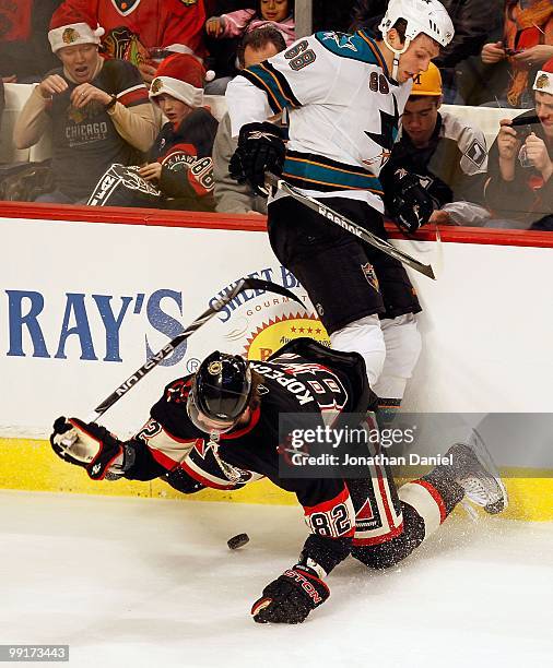 Frazer McLaren of the San Jose Sharks dumps Tomas Kopecky of the Chicago Blackhawks as they battle for the puck at the United Center on December 22,...