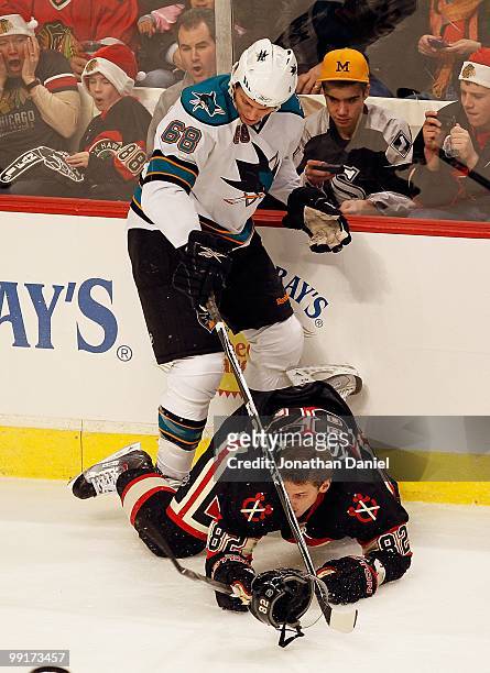 Frazer McLaren of the San Jose Sharks dumps Tomas Kopecky of the Chicago Blackhawks as they battle for the puck at the United Center on December 22,...