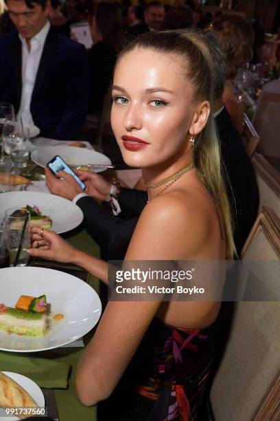 Kristina Romanova poses for a picture as she wins the Chopard auction during amfAR Paris Dinner 2018 at The Peninsula Hotel on July 4, 2018 in Paris,...