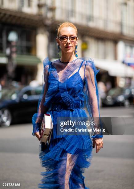 Elina Halimi wearing blue ruffled dress, ankle boots is seen outside Elie Saab on day four during Paris Fashion Week Haute Couture FW18 on July 4,...