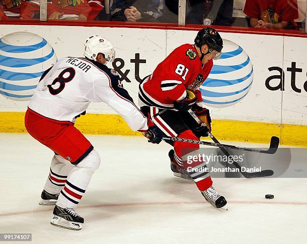 Marian Hossa of the Chicago Blackhawks controls the puck under pressure from Jan Hejda of the Columbus Blue Jackets at the United Center on January...