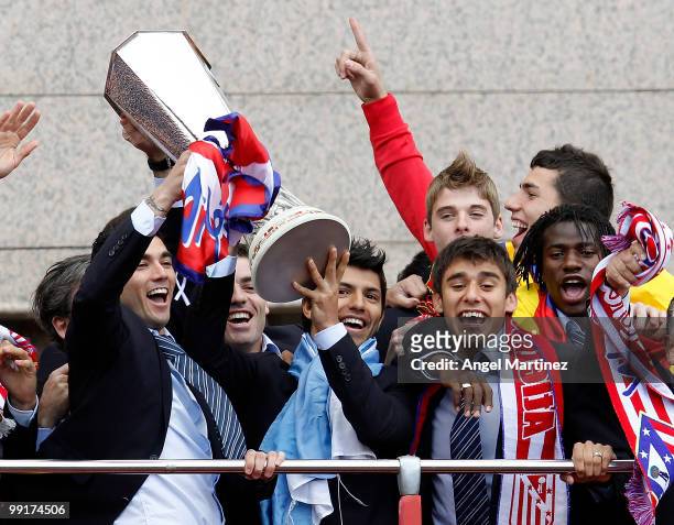 Atletico Madrid players Jose Antonio Reyes, Sergio Aguero, Salvio and Ibrahima celebrate with the trophy on the top of an open bus in Madrid the day...