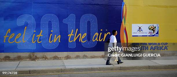 South African woman walks by a Soccer World Cup 2010 giant advertising billboard on May 13, 2010 in Port Elizabeth, South Africa. Port Elizabeth will...