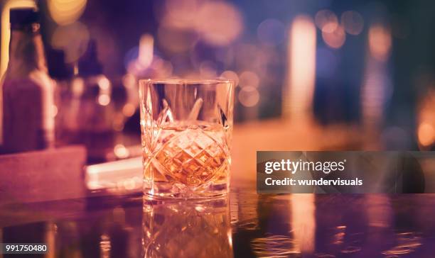 whisky auf eis serviert im vintage glas in bar - gold bars stock-fotos und bilder