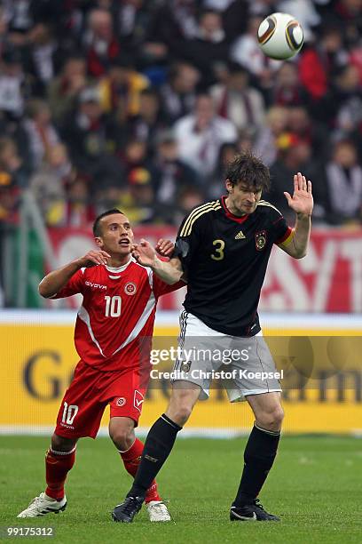 Andrew Cohen of Malta and Arne Friedrich of Germany go up for a header during the international friendly match between Germany and Malta at Tivoli...