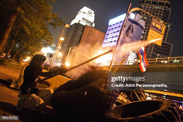 An anti-government 'Red Shirt' protester fires a home made rocket towards Thai security forces from inside their encampment on May 13, 2010 in...