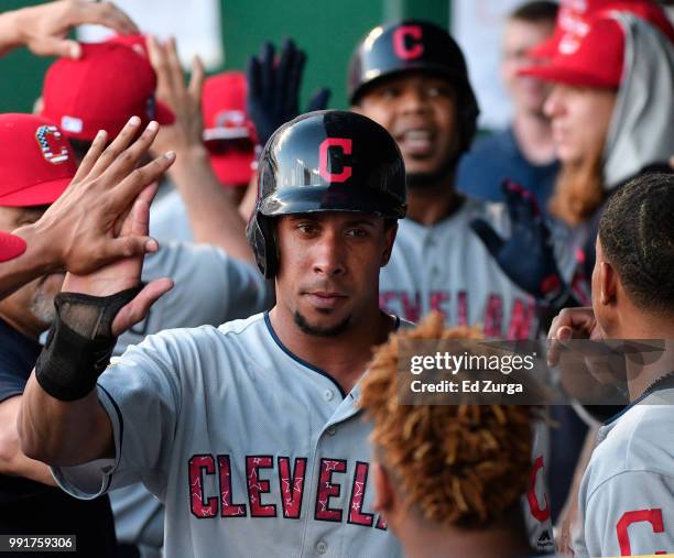 Michael Brantley of the Cleveland Indians celebrates with teammates after scoring on a sacrifice fly off the bat of Edwin Encarnacion in the first...