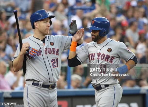 Jose Bautista of the New York Mets is congratulated by Todd Frazier after scoring a run in the fifth inning during MLB game action against the...