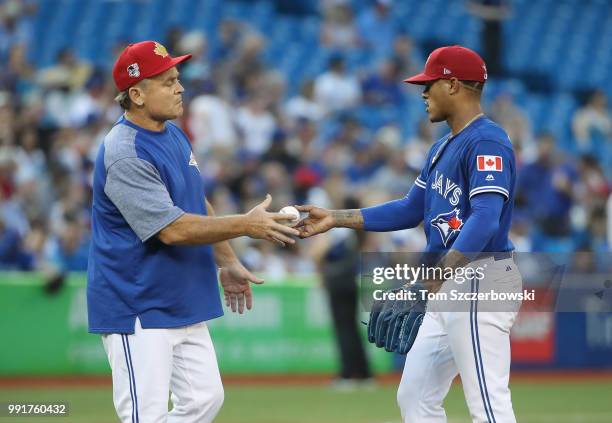 Marcus Stroman of the Toronto Blue Jays hands the baseball to manager John Gibbons as he is relieved in the fifth inning during MLB game action...