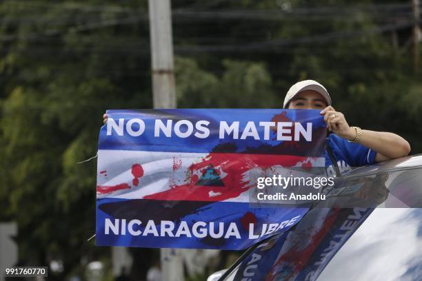 Protester holding a poster attends a protest against Nicaraguan President Daniel Ortega's government in Managua, Nicaragua on July 04, 2018....