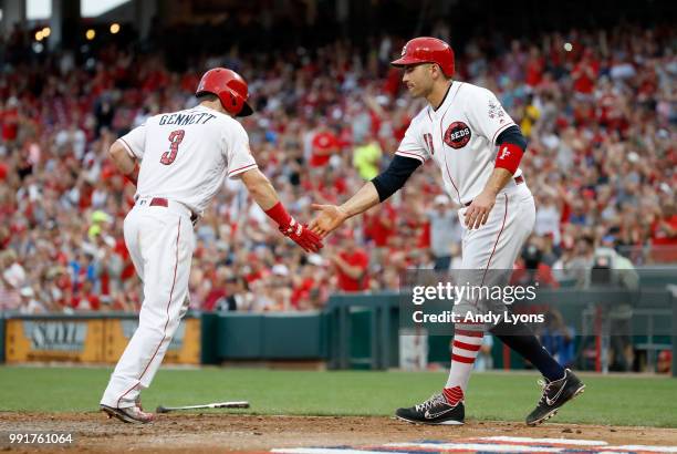 Scooter Gennett and Joey Votto of the Cincinnati Reds congratulate each other after scoring in the 4th inning against the Chicago White Sox at Great...