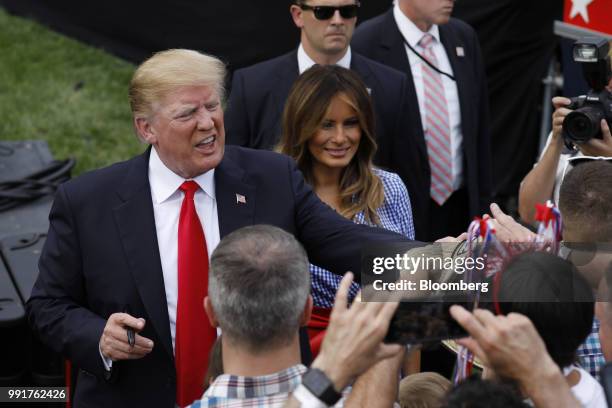 President Donald Trump, left, and First Lady Melania Trump, center, greet guests at a picnic for military families in Washington, D.C., U.S., on...