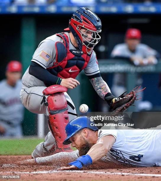 The Kansas City Royals' Alex Gordon scores as Cleveland Indians catcher Roberto Perez drops the throw on a steal of home plate in the second inning...