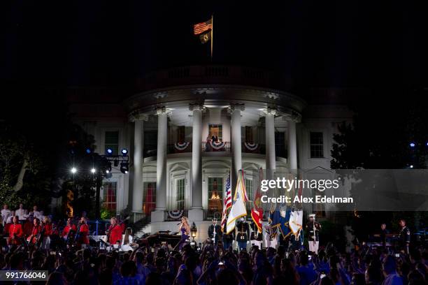 President Donald Trump and first lady Melania Trump watch the US airforce band perform the National Anthem prior to viewing fireworks at the White...