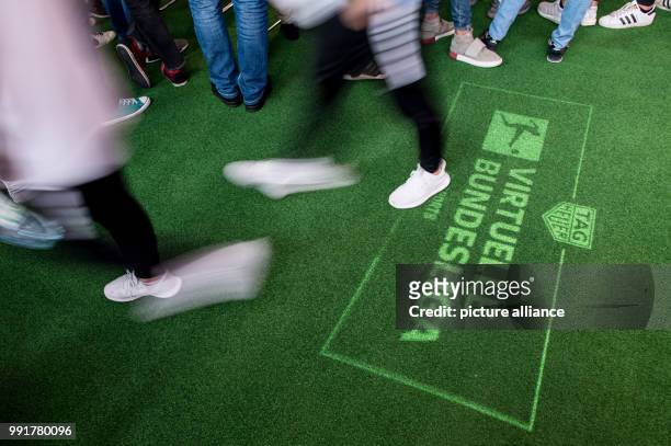 Nordrhein-Westfalen, Dortmund: Finale 2017/2018 der Virtuellen Bundesliga. Ein Besucher geht über einen Teppich, wo per Licht das Logo der Virtuellen...