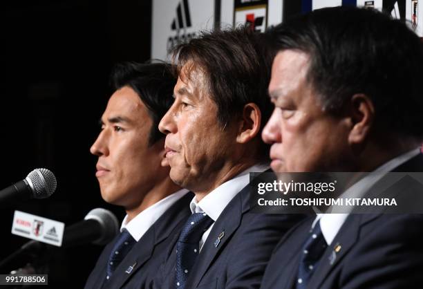 Japan's national football team head coach Akira Nishino poses with captain Makoto Hasebe and Japan Football Association chairman Kozo Tashima during...