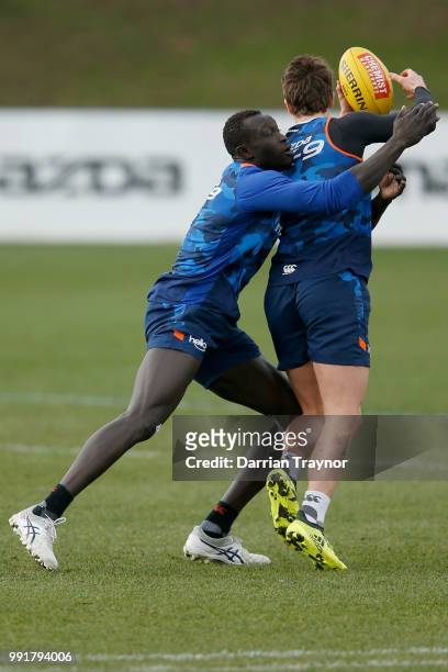 Majak Daw of the Kangaroos does some tackling practice during a North Melbourne Kangaroos AFL training session at Arden Street Ground on July 5, 2018...