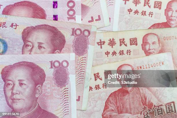 Banknotes of Renminbi and New Taiwan dollar arranged for photography on July 03 2018 in Hong Kong, Hong Kong. The Chinese yuan has been slumping for...