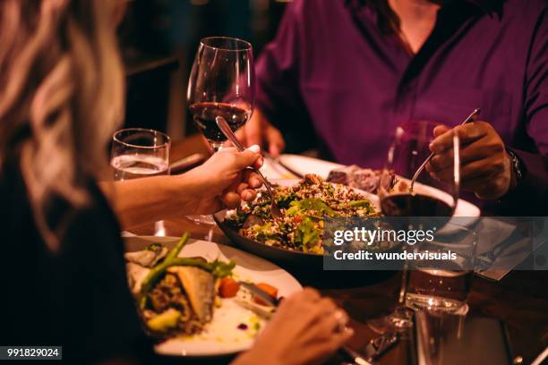 couple eating quinoa salad and healthy dinner at restaurant - date night stock pictures, royalty-free photos & images