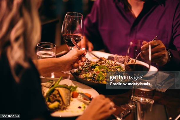 couple eating quinoa salad and healthy dinner at restaurant - romantic restaurant posh stock pictures, royalty-free photos & images