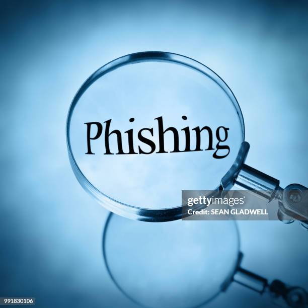 magnifying glass with the word phishing magnified - phishing email stock pictures, royalty-free photos & images