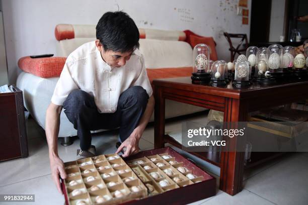 Sixty-year-old Zeng Huosheng presents his works on eggshells at home on June 26, 2018 in Hangzhou, Zhejiang Province of China.