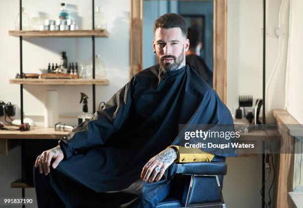 cool hipster man portrait in barber chair. - barbiere foto e immagini stock