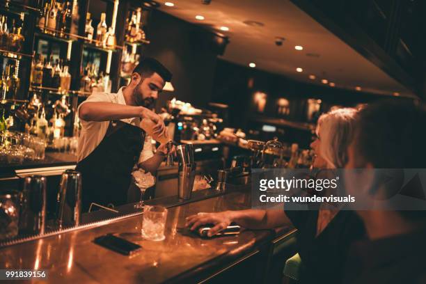 barkeeper cocktails an retro-bar für älteres paar machen - young professional at party stock-fotos und bilder