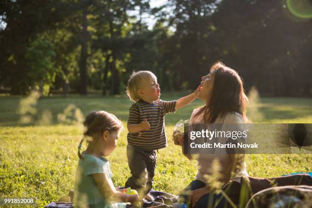 kid putting jelly in mother's mouth - baby nature fotografías e imágenes de stock