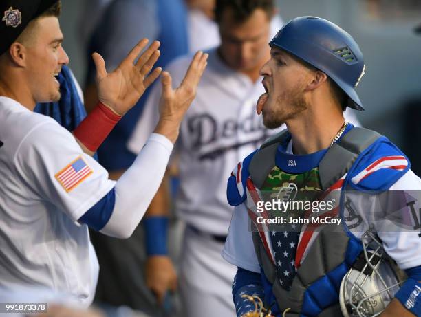 Enrique Hernandez of the Los Angeles Dodgers and Yasmani Grandal in the dugout before playing the Pittsburgh Pirates at Dodger Stadium on July 2,...