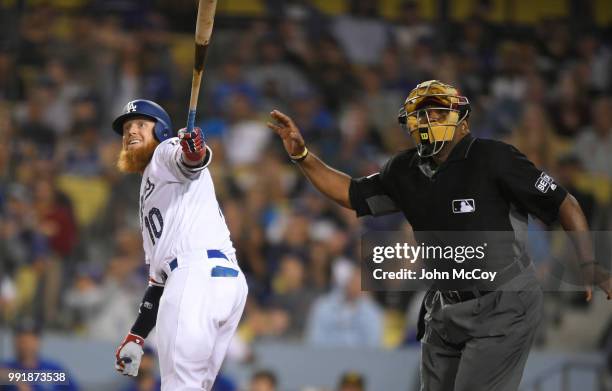 Justin Turner of the Los Angeles Dodgers hits the ball foul in the fourth inning as umpire Laz Diaz watches in a game against the Pittsburgh Pirates...