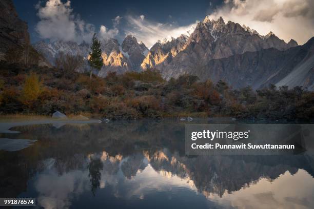 reflection of passu cathedral at sunset, karakorasm mountain range, gilgit baltistan, pakistan - gilgit stockfoto's en -beelden