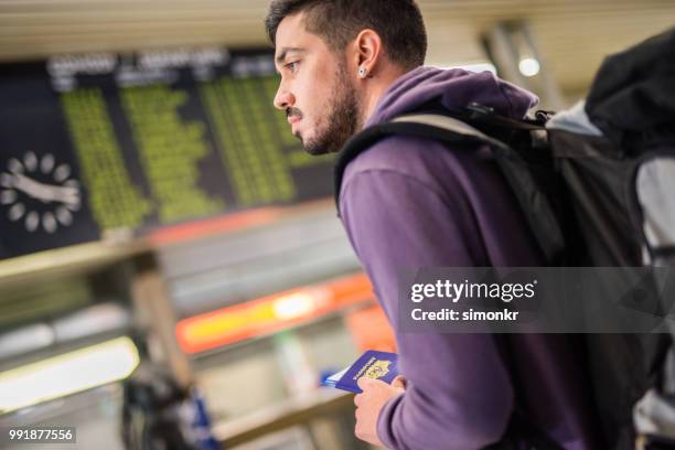 businessman holding passport at airport - earring card stock pictures, royalty-free photos & images