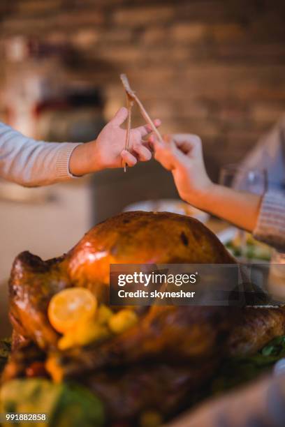 unrecognizable children pulling wishbone on thanksgiving dinner. - wishbone stock pictures, royalty-free photos & images