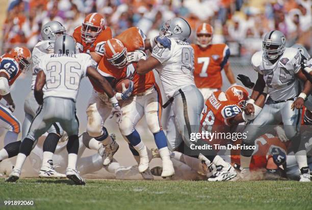 Chester McGlockton, Defensive Tackle for the Los Angeles Raiders tackles Derrick Clark, Running Back for the Denver Broncos during their American...