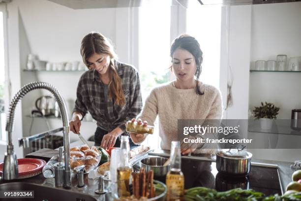 vrienden samen thuis koken - cooking together stockfoto's en -beelden