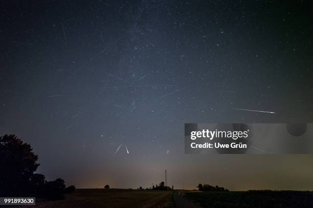 perseid meteor shower & satellite tracks - grün stock pictures, royalty-free photos & images