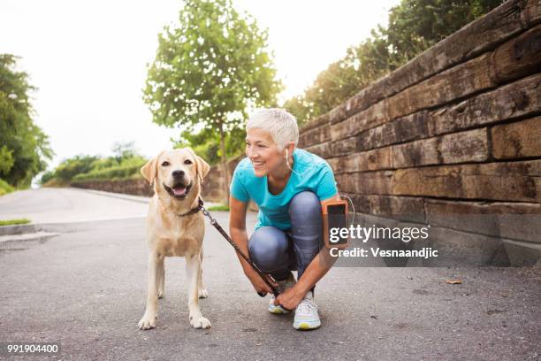 kvinnan kör med hennes hund - street running bildbanksfoton och bilder