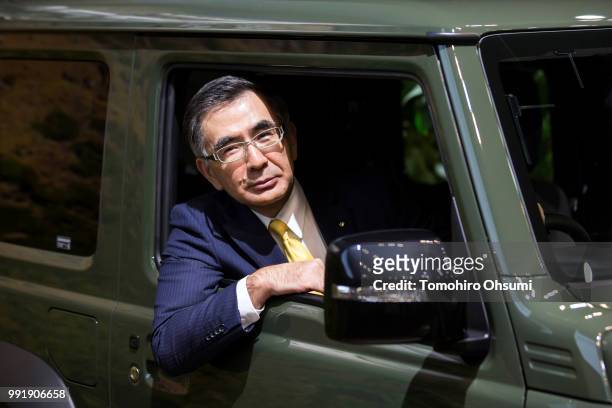 Suzuki Motor Corp. President Toshihiro Suzuki sits in the driver's seat of a Jimny Sierra four-wheel drive off-road car during a photo session after...