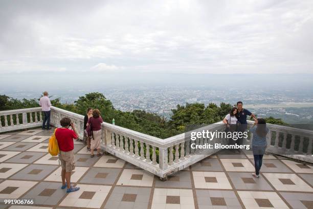 Tourists take photos of the Chiang Mai skyline from the Wat Phra That Doi Suthep in Chiang Mai, Thailand, on Wednesday, July 4, 2018. Thai inflation...
