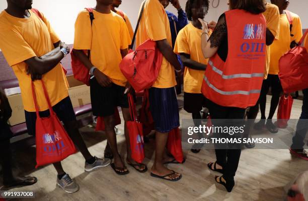 French official speaks to some of the 50 migrants as they wait in the immigration hall at Roissy-Charles de Gaulle airport on the outskirts of Paris...