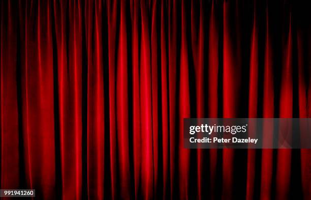 darkly lit theatre curtains - rood stof stockfoto's en -beelden