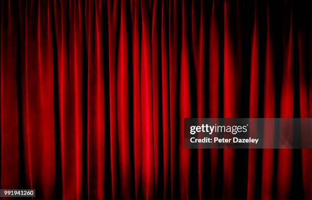 darkly lit theatre curtains - red flag stock pictures, royalty-free photos & images
