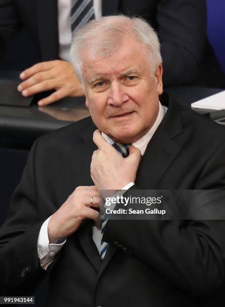 German Interior Minister and leader of the Bavarian Social Union , Horst Seehofer, adjusts his tie at the last session of the Bundestag before the...