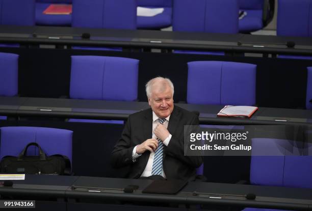 German Interior Minister and leader of the Bavarian Social Union , Horst Seehofer, adjusts his tie at the last session of the Bundestag before the...