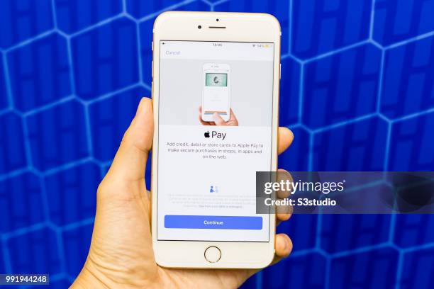 In this photo illustration, A man holds a smart phone with Apple Pay application is displayed on the screen on July 05 2018 in Hong Kong, Hong Kong.